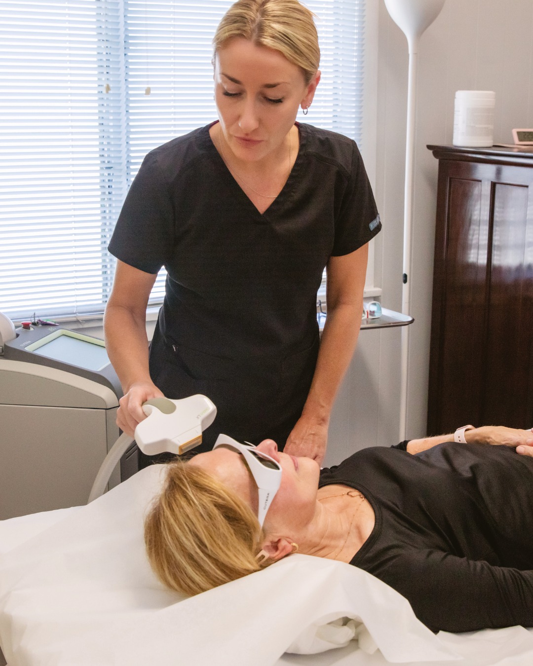 Paradise Medical Maui, Woman receives laser skin treatment from a technician in a medical setting.