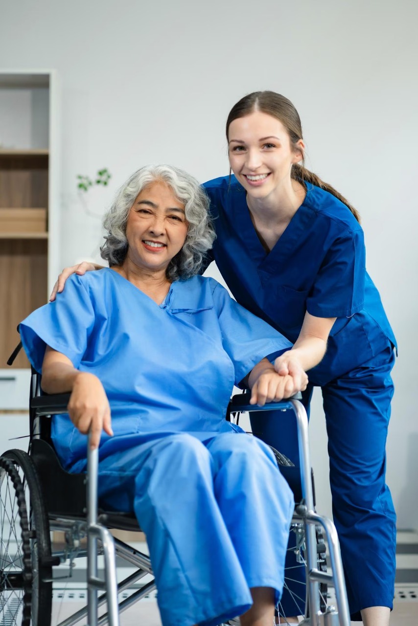 Paradise Medical Maui, Elderly woman in wheelchair with caregiver smiling