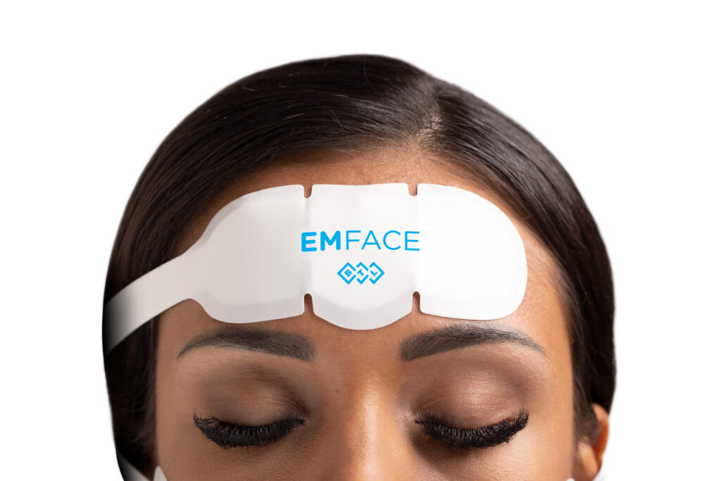 Paradise Medical Maui, Woman with Emface device on forehead. Emface logo visible.