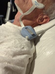 Paradise Medical Maui, Elderly man wearing an Emface device while lying in bed.