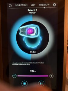 Exomindtherapy device screen showing intensity settings at 100%.